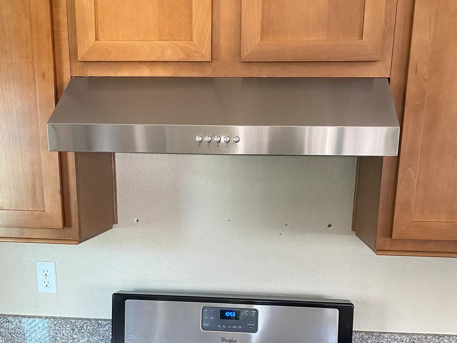Stainless under-cabinet range hood installed above a range