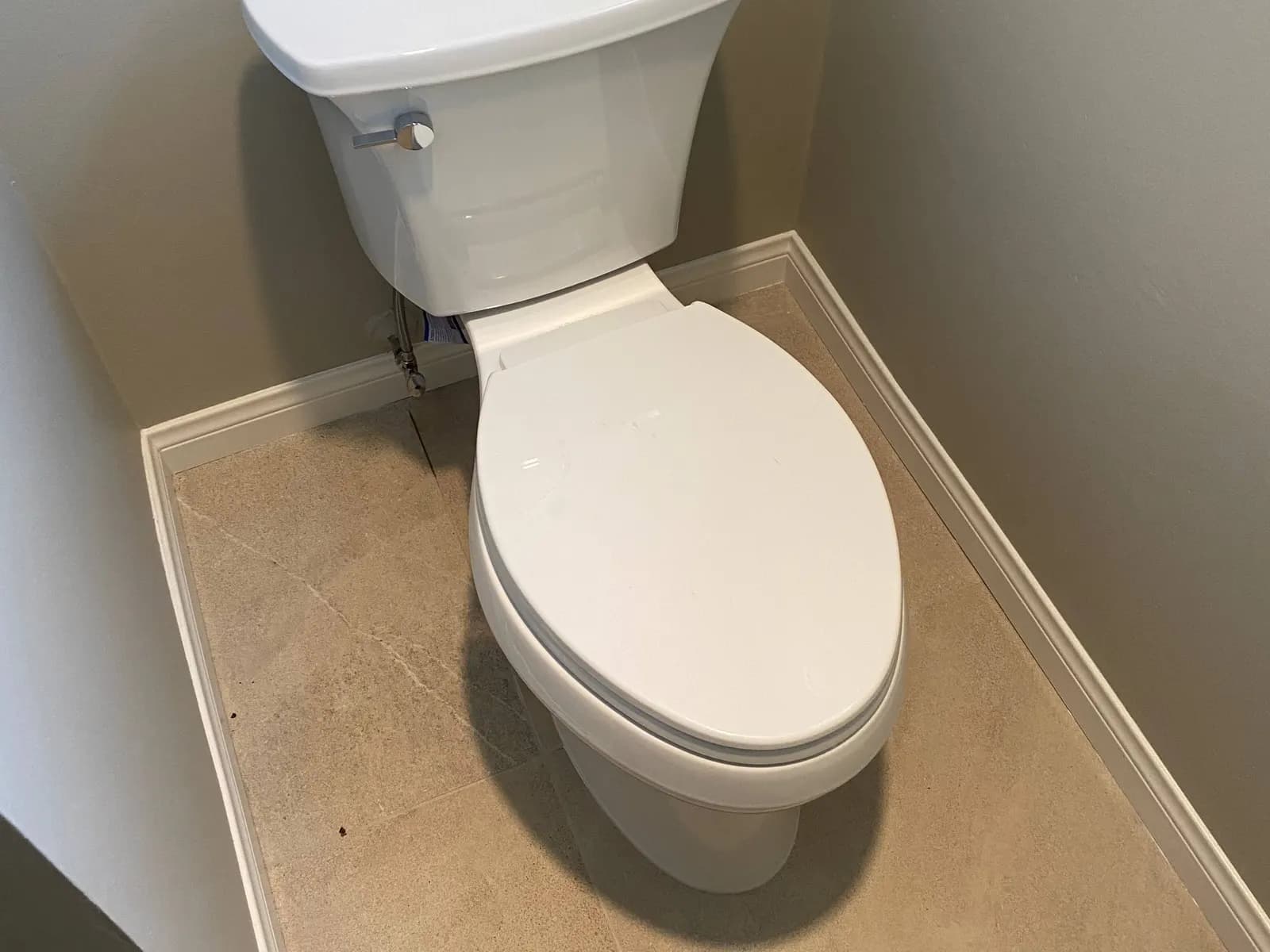 Newly installed white toilet in a small bathroom