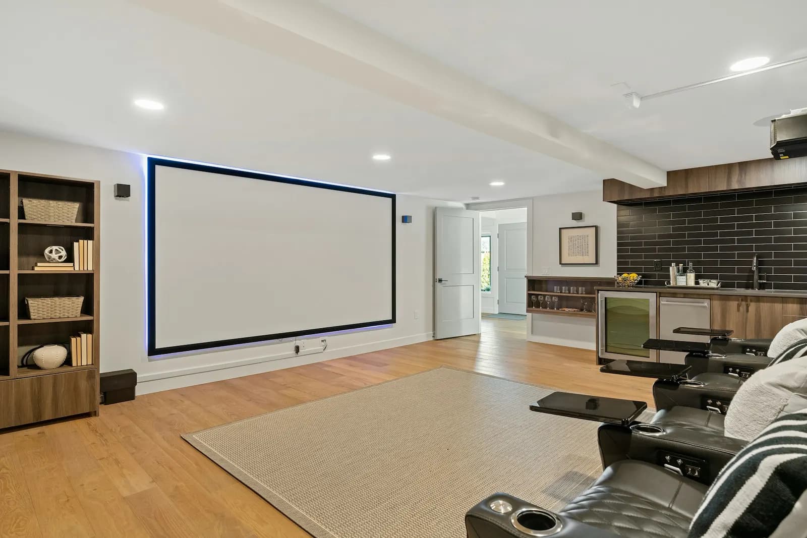 Media room with a large projection screen, recliners and shelving